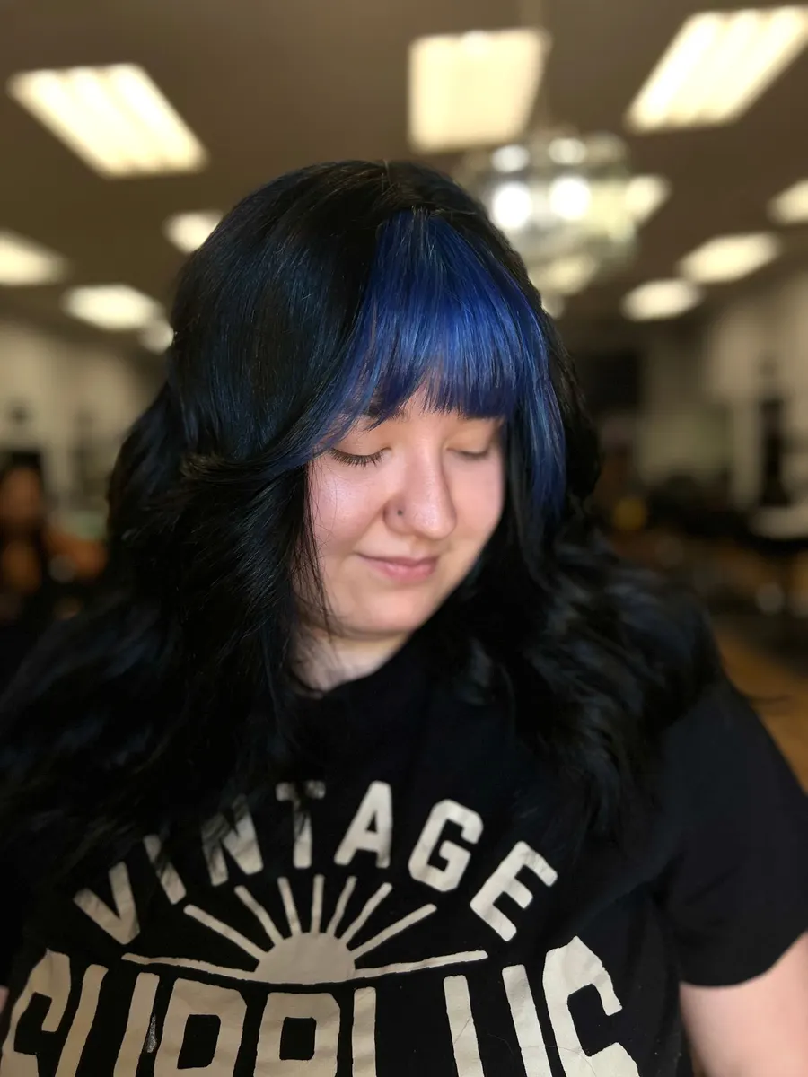 Black hair with blue panels and curtain bangs